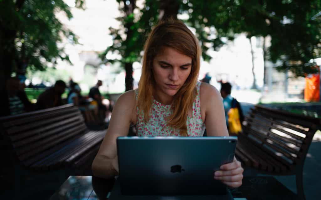 woman in a park working on her laptop