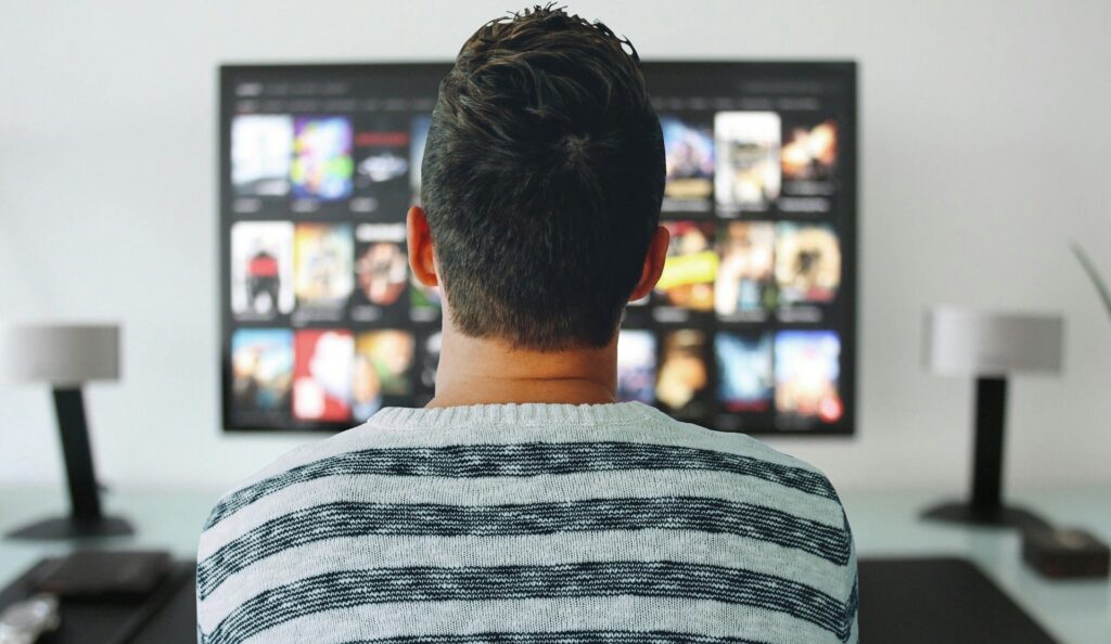 A man choosing something to watch on the television.