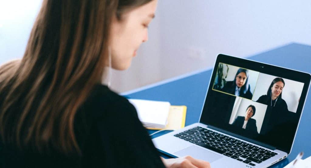 A woman conducting online meeting via Zoom on her laptop.