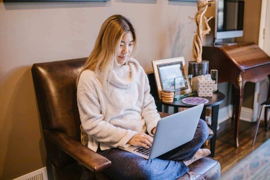 a woman sitting on a chair using a laptop
