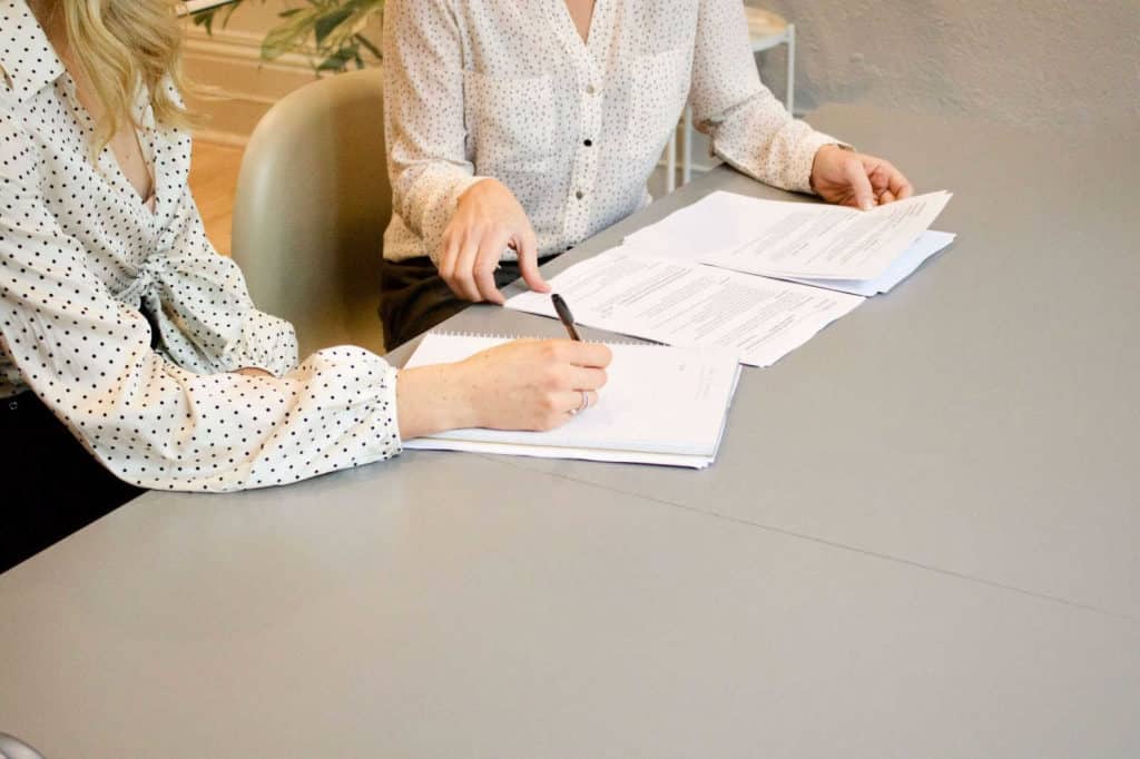 2 women working on documents ready for Insurance transcription