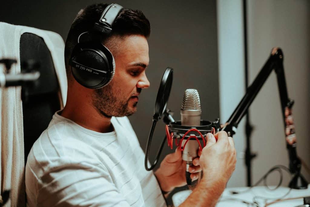 Man speaking into a microphone for podcast transcript