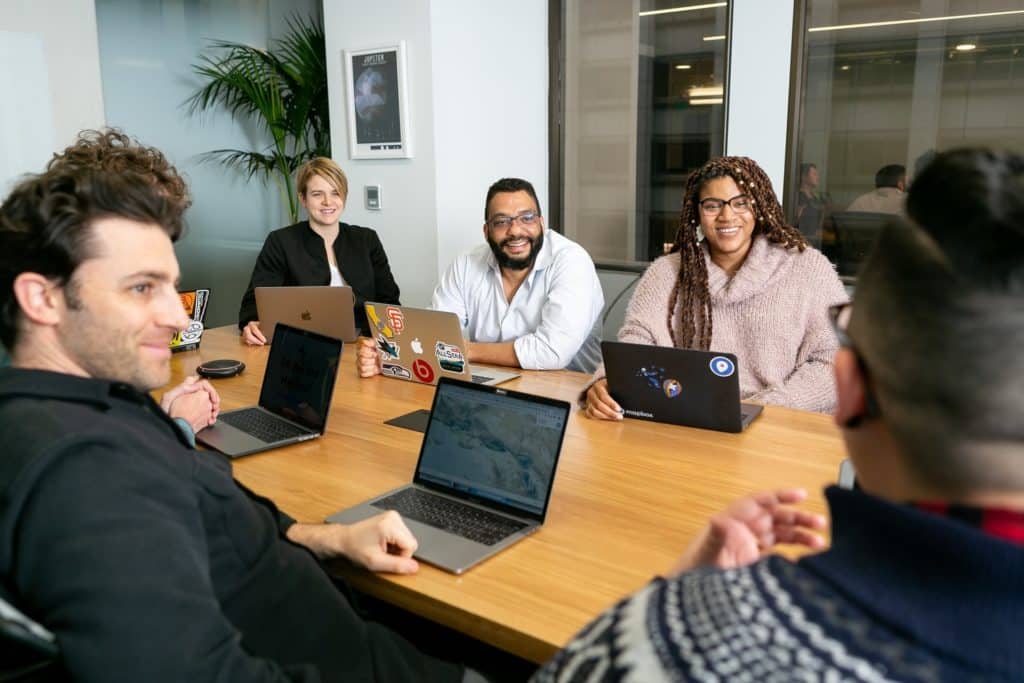 People with their laptops meeting in a conference room