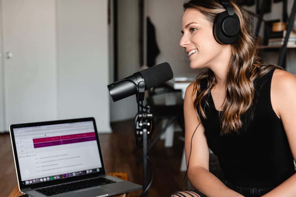 Woman speaking into a microphone for podcast transcription