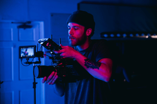 man wearing a beanie hat holding up a camera
