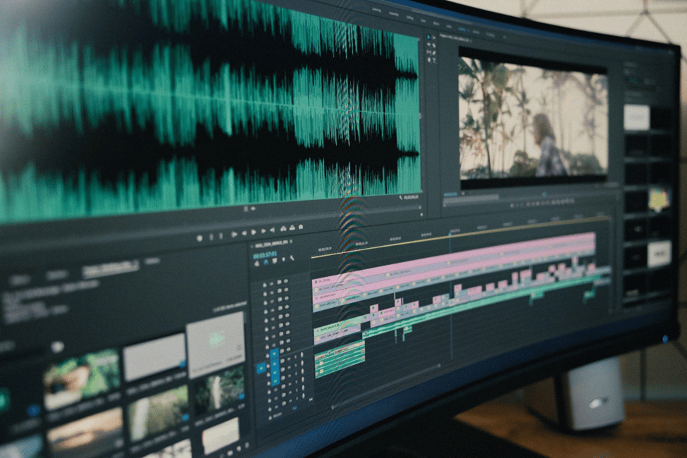 a wide monitor displaying an audio video editing software and subtitles in adobe premiere