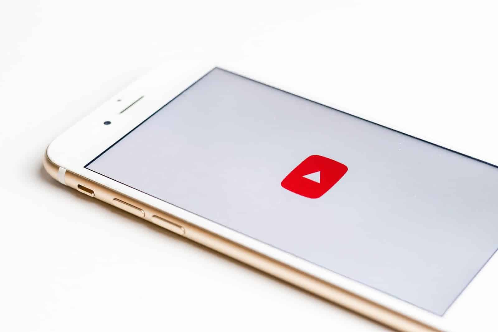 mobile phone displaying youtube icon on a white background