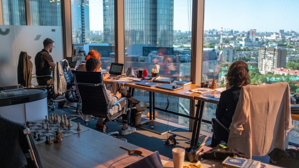People in an office next to a window looking at a city