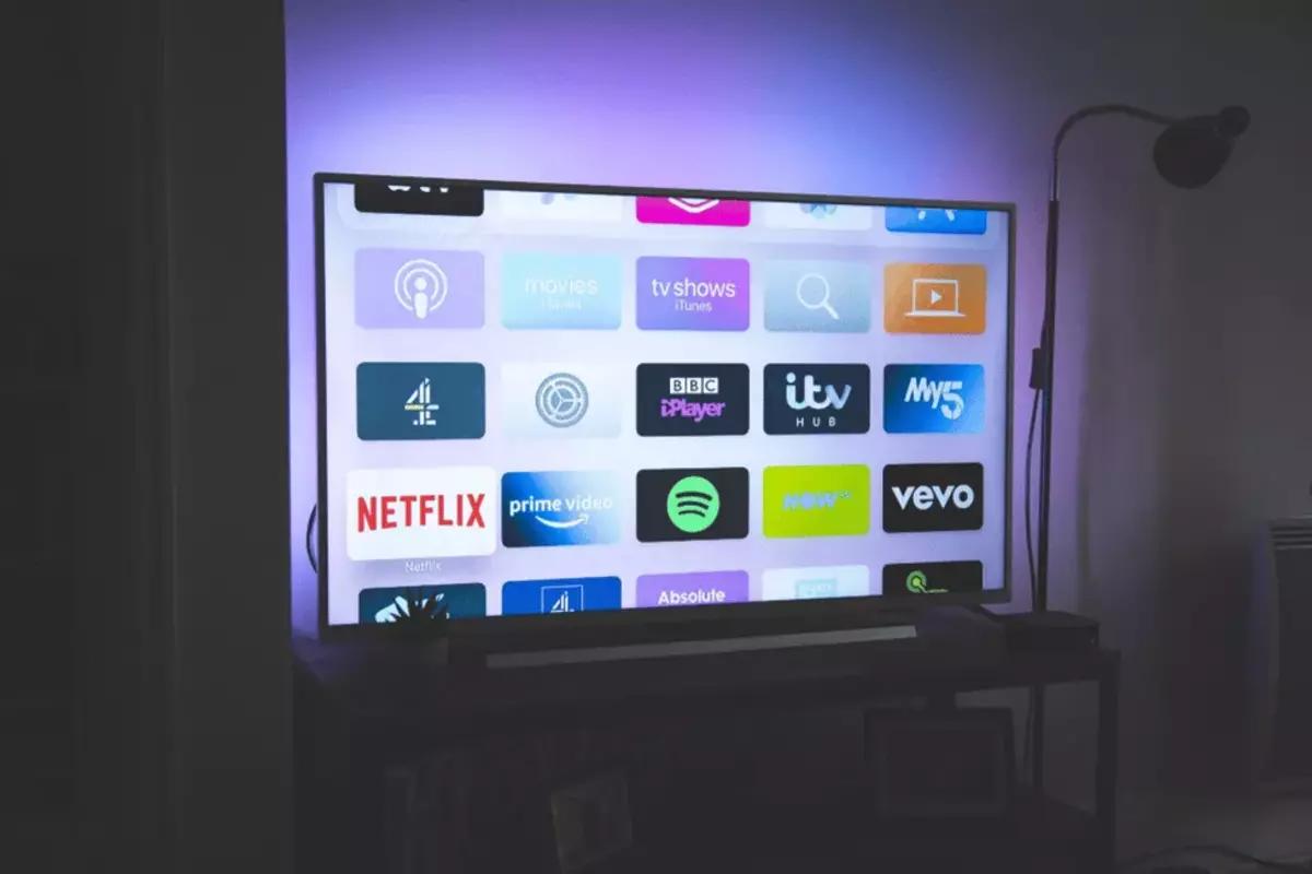 a television displaying icons of different apps, with lighting behind it
