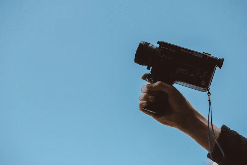 a hand holding up a video camera
