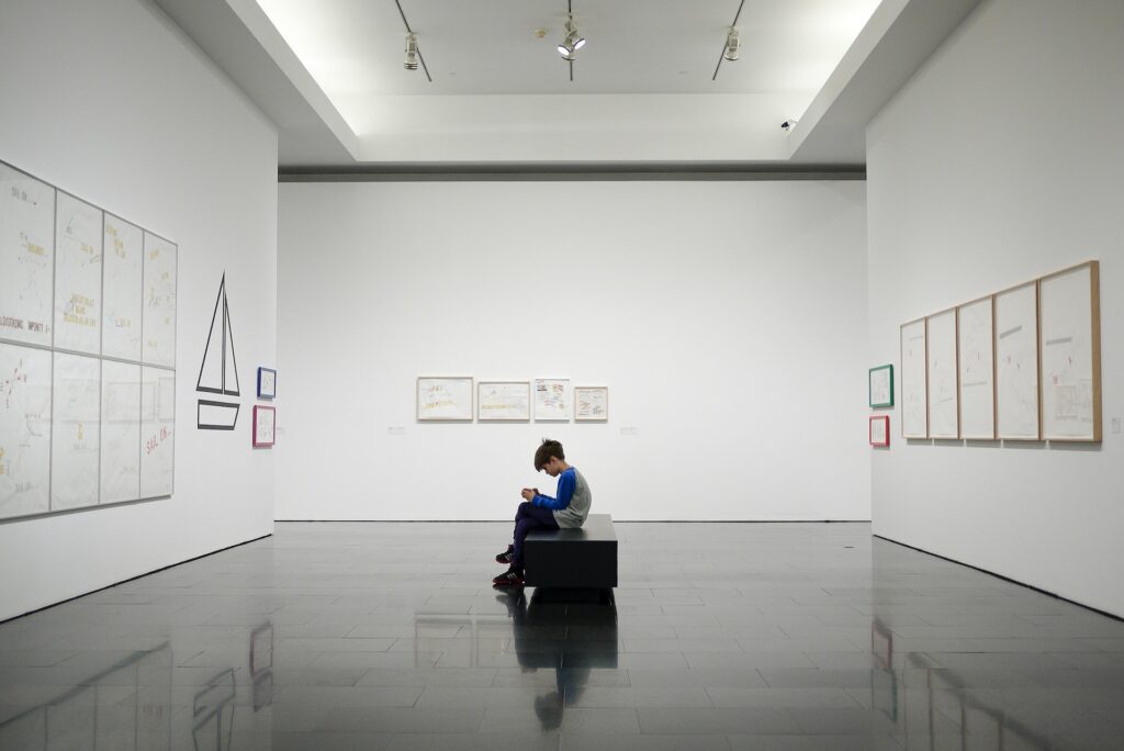 Person sitting on a bench in a museum art gallery