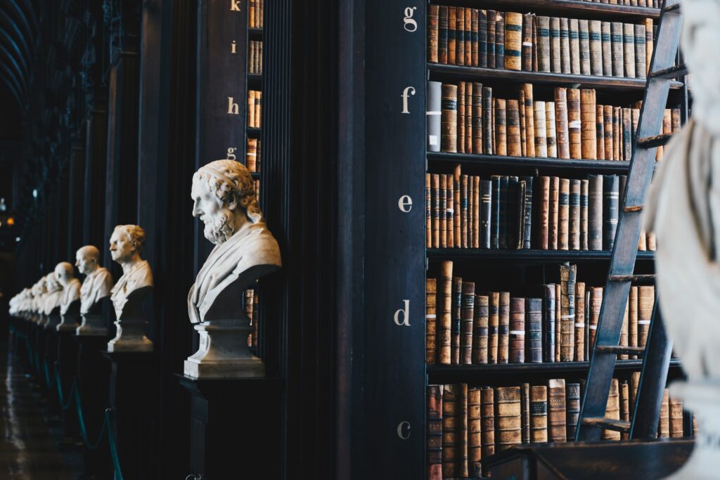 Inside of a library with rows of books and statues