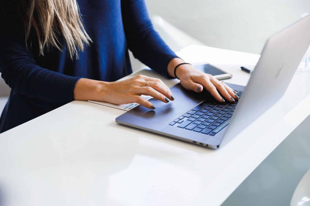 Woman's hands typing on a laptop computer.
