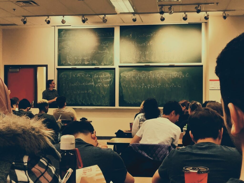 instructor lecturing at a chalk board