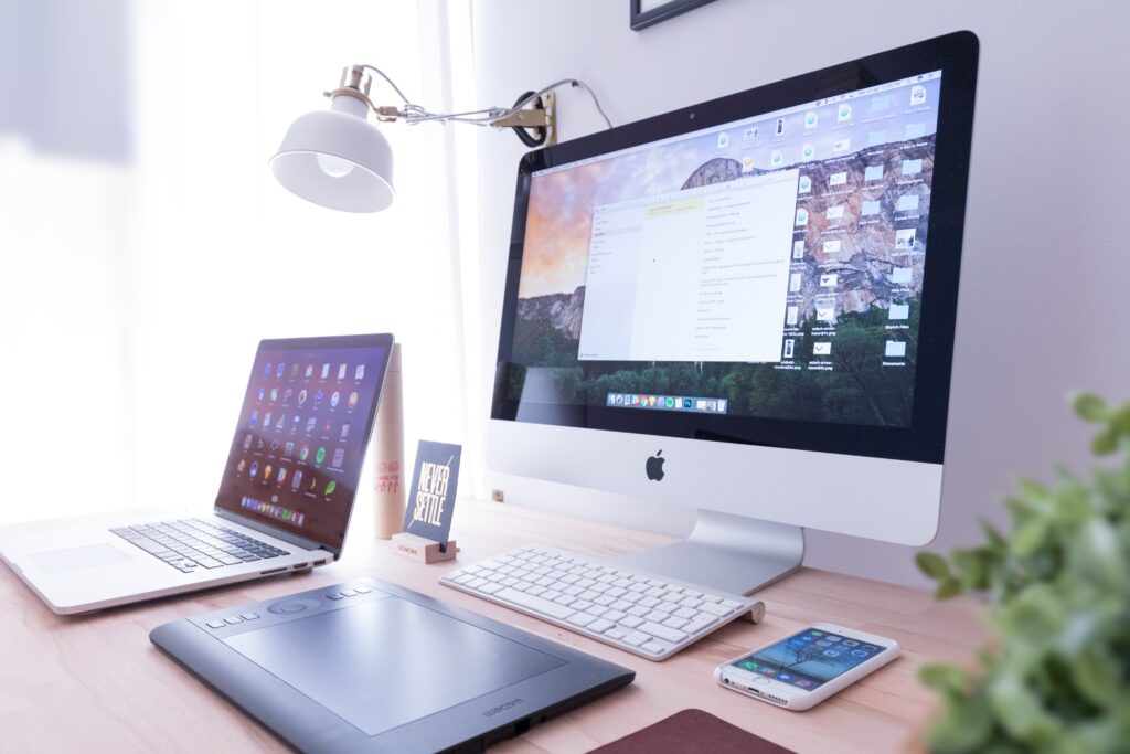 laptop, imac and other devices on a table