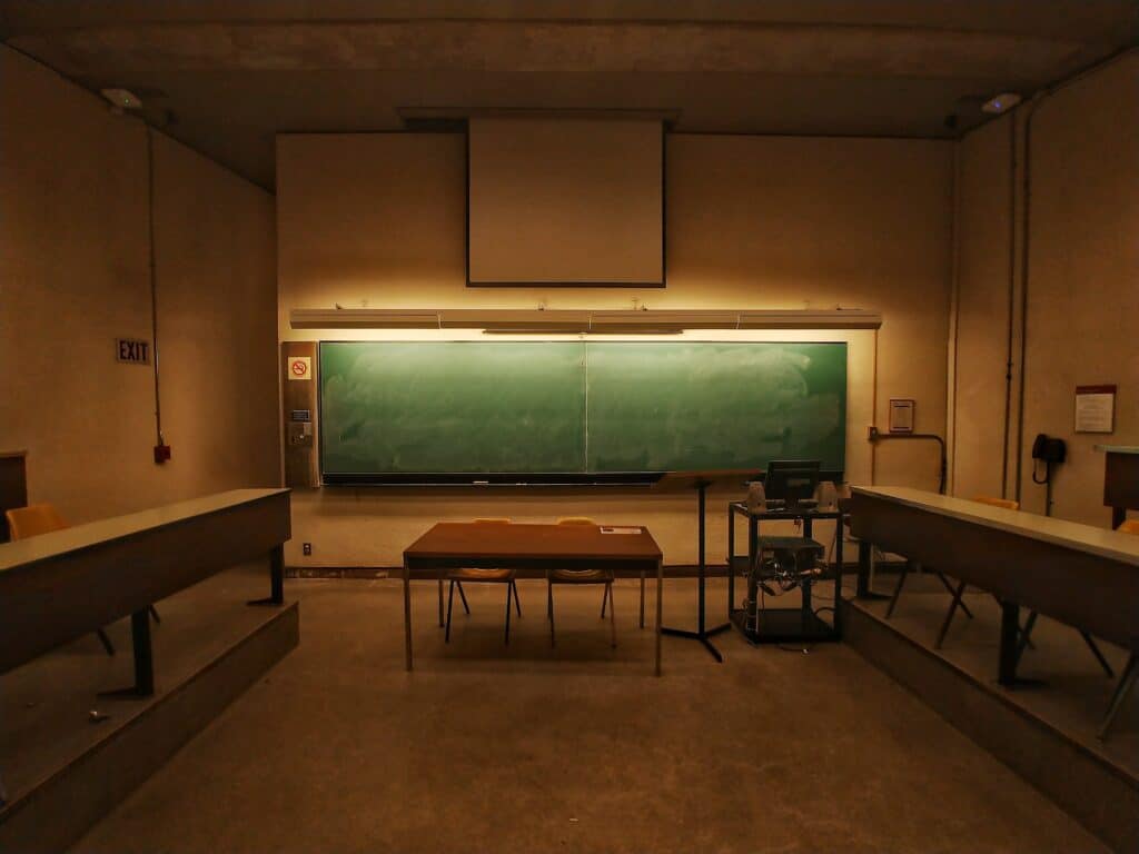 an empty classroom with blackboard in front