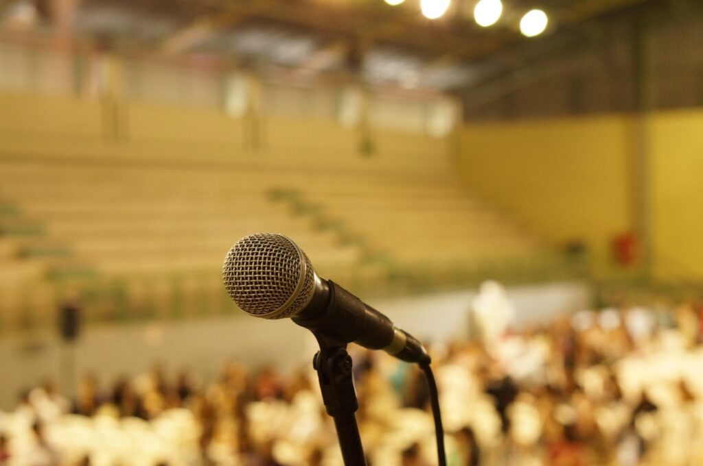 a microphone in front of a crowd of listeners