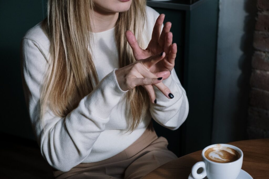 a woman in a coffee shop using sign language