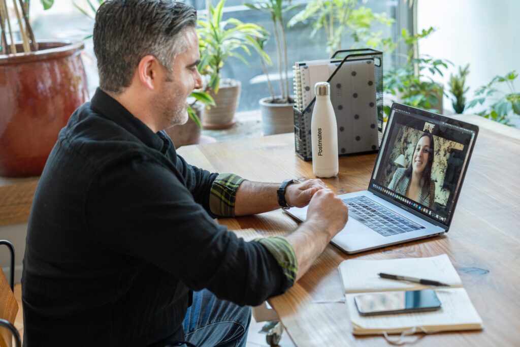 a man and a woman smiling and talking on a video conference call