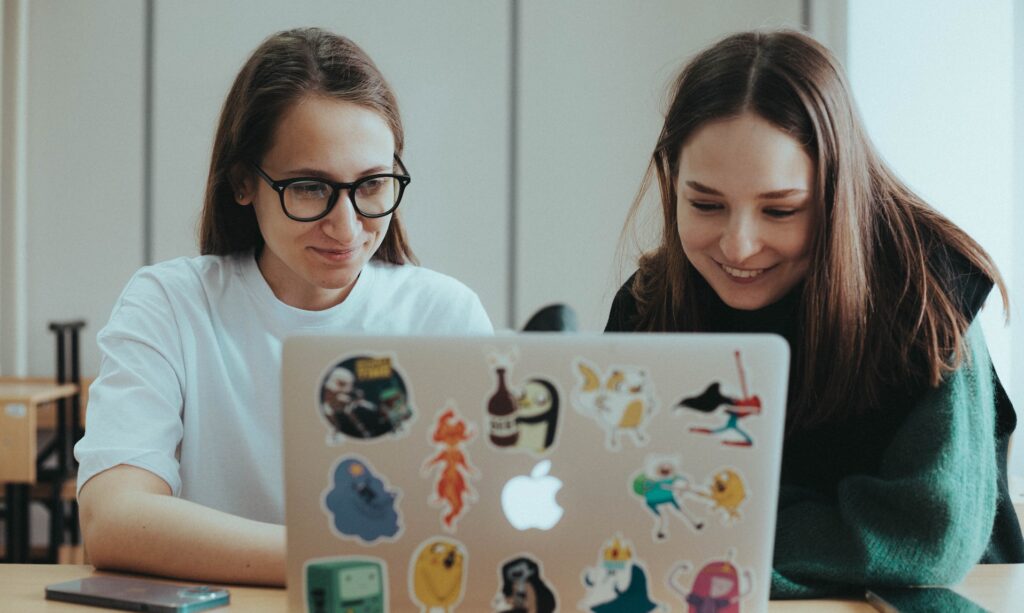 two college students looking at a laptop computer
