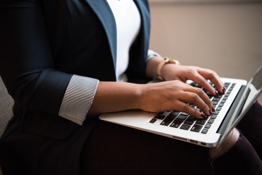 woman in a suit typing on a computer