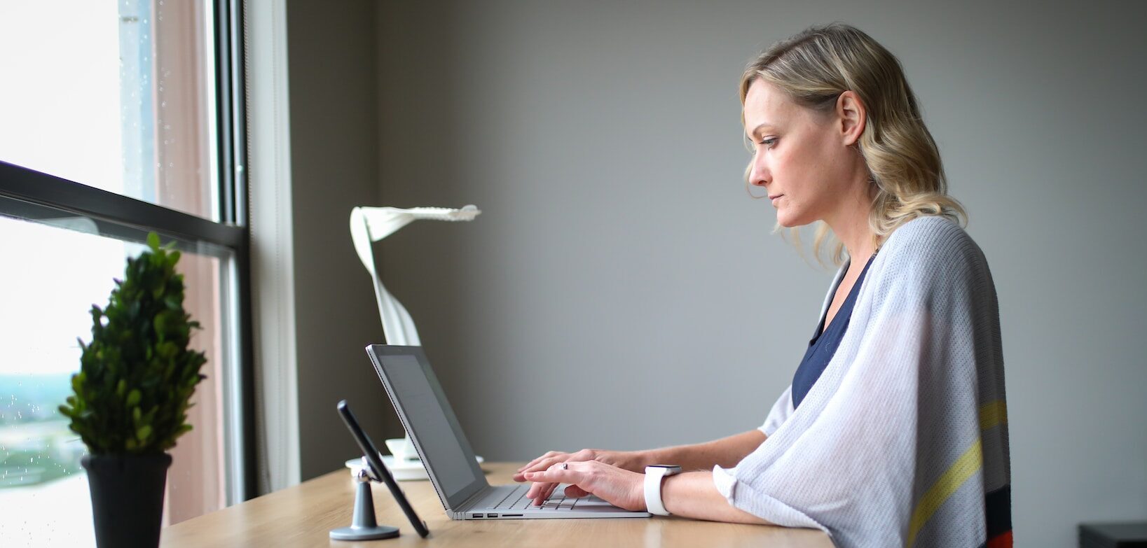 woman working at a sit to stand desk