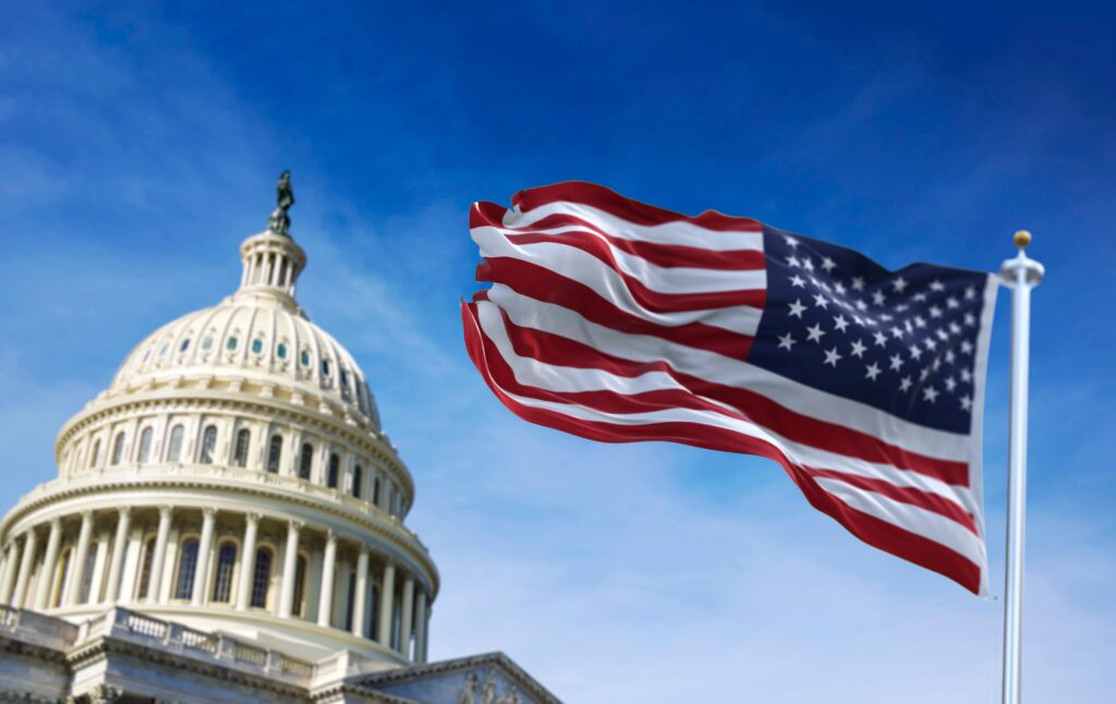 The American flag flying in the wind in front of a government building