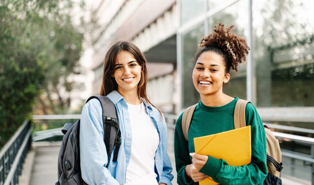 two female students smiling on a university campus