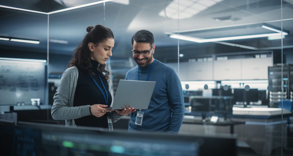 a woman and a man working on a computer in a modern looking office