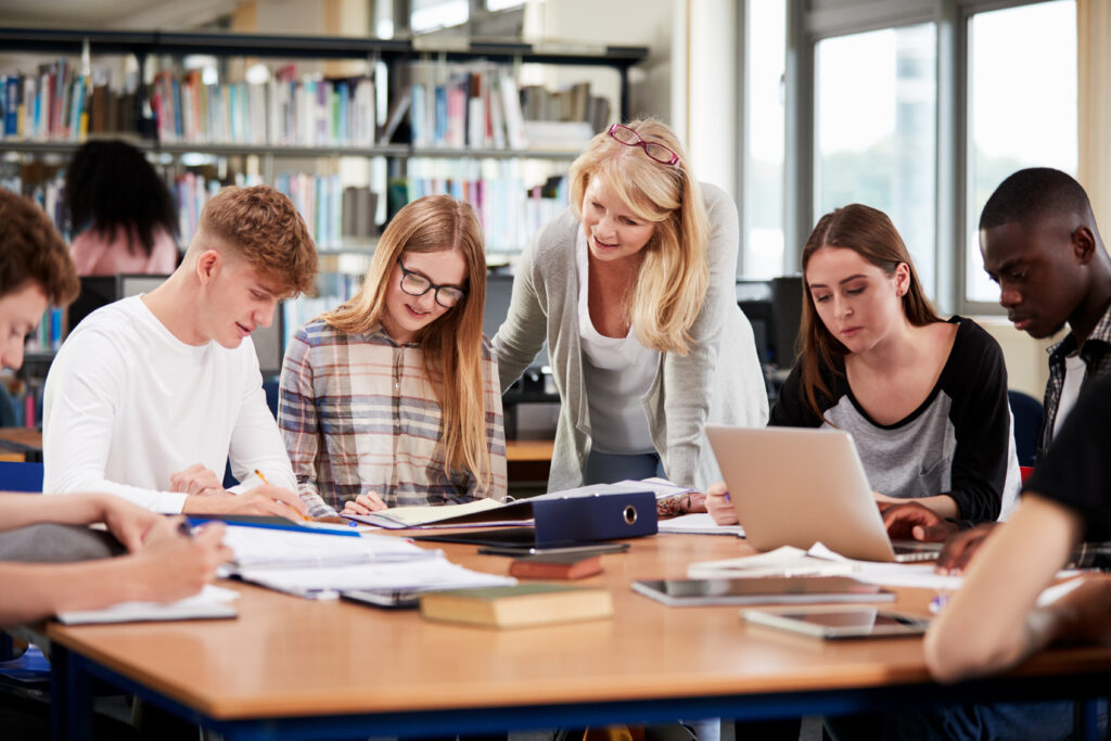 students in a library with a teacher