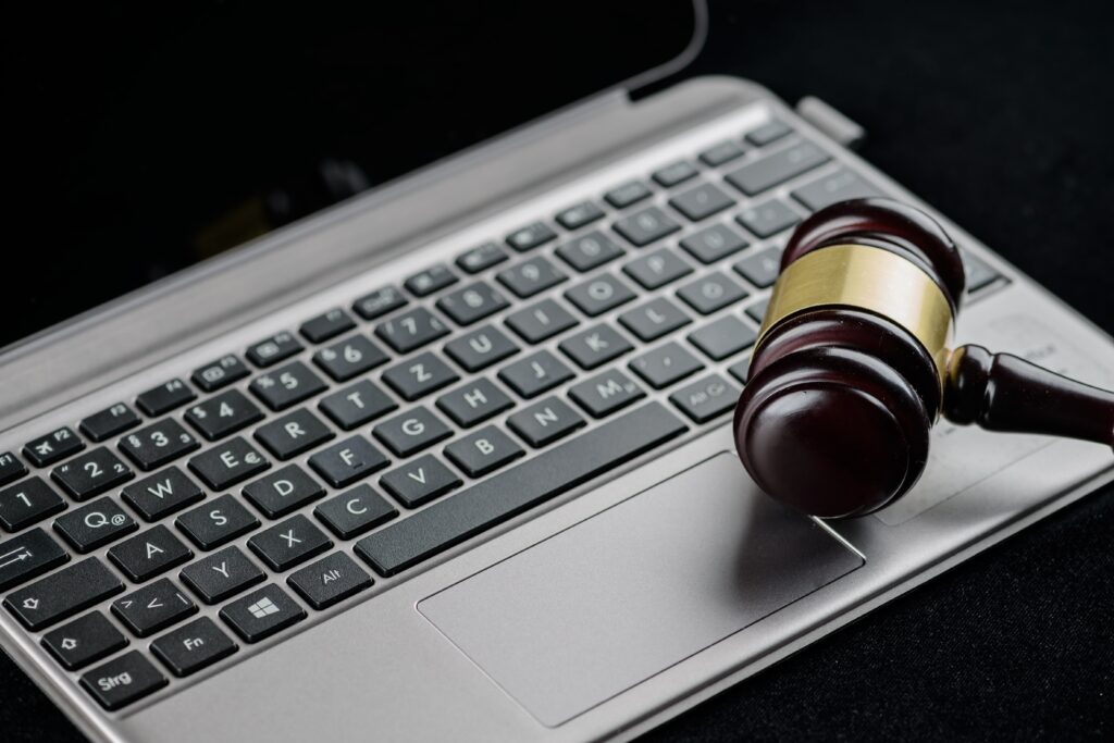 A computer with a judge's gavel resting on the keyboard