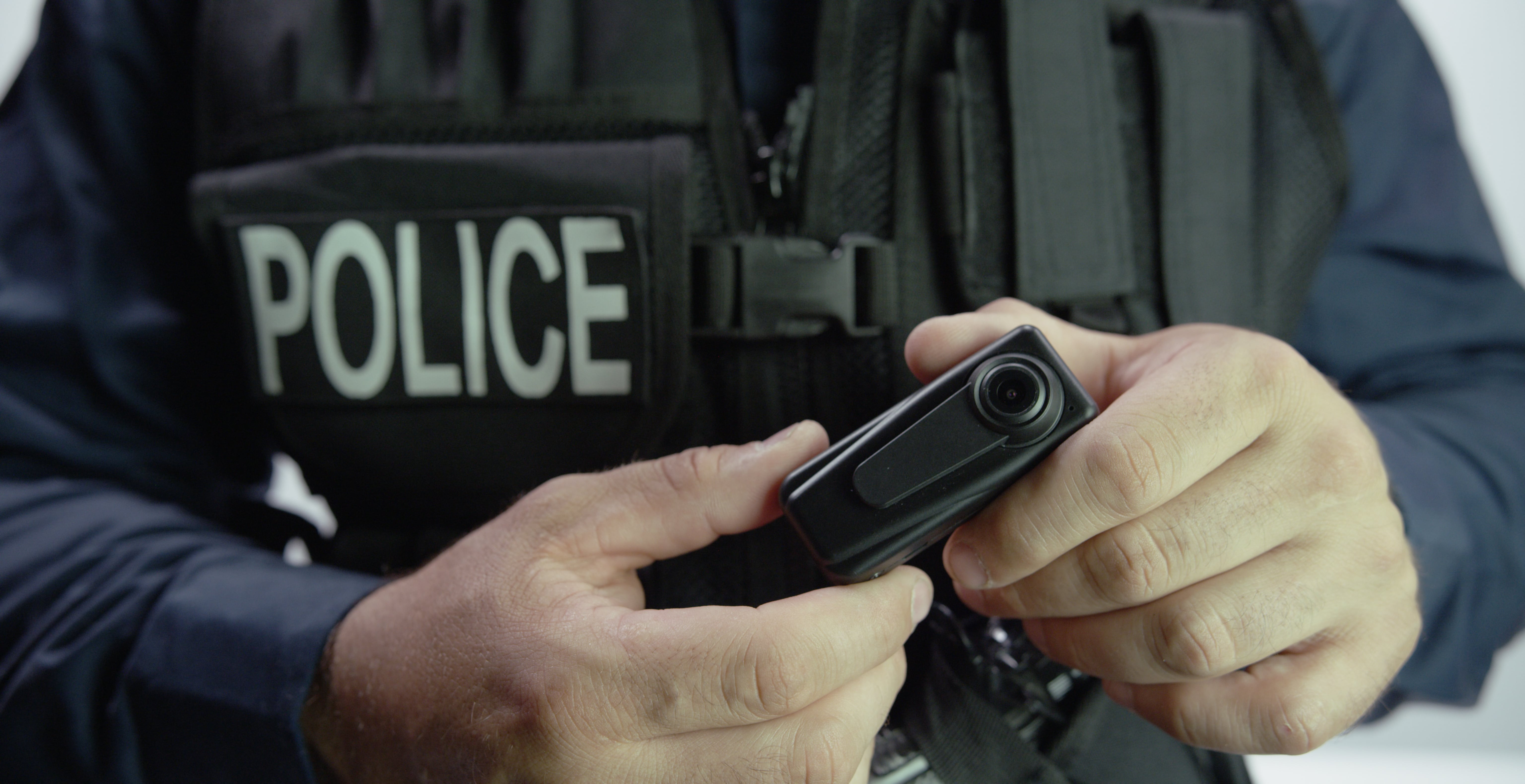 a police officer holding a body-worn camera