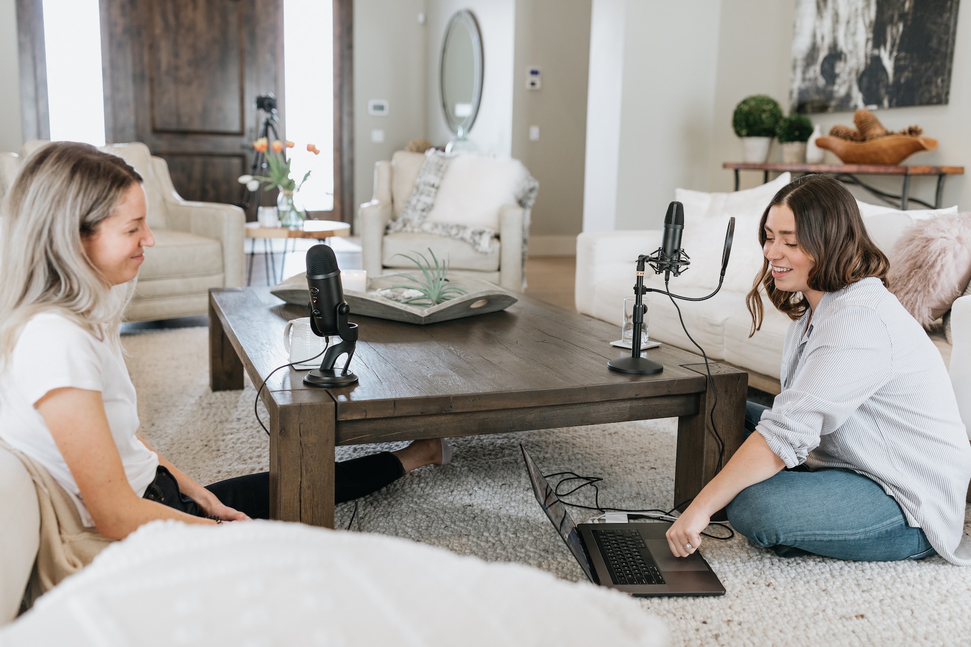 two women sitting on the floor doing a podcast