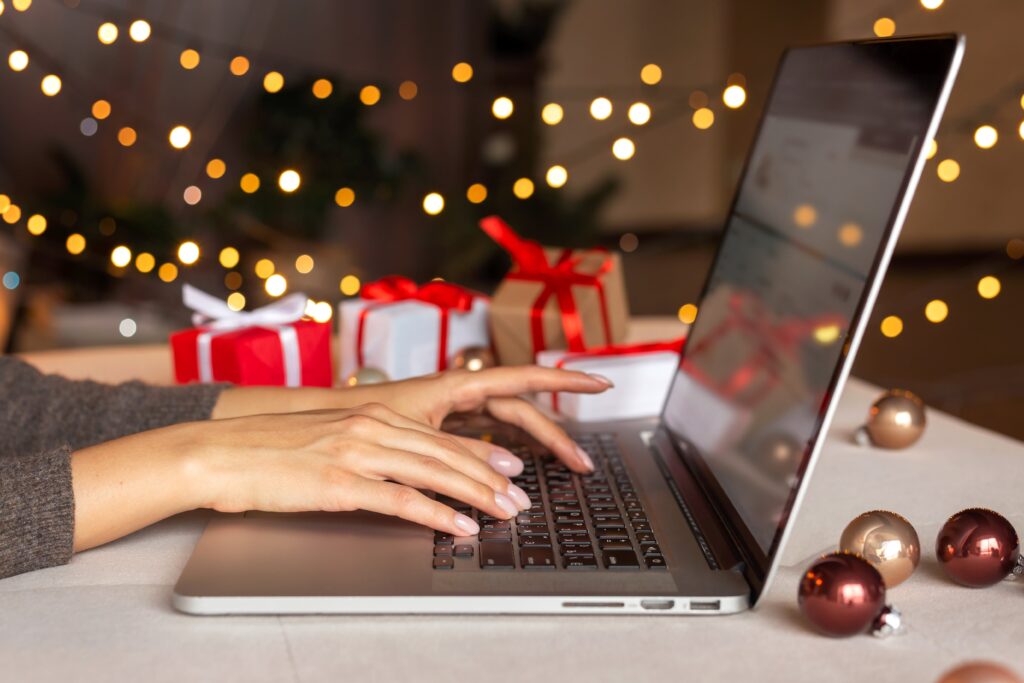a person shopping on a laptop with holiday decorations in the background