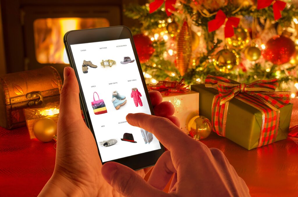 person shopping on a mobile phone with Christmas decorations in the background