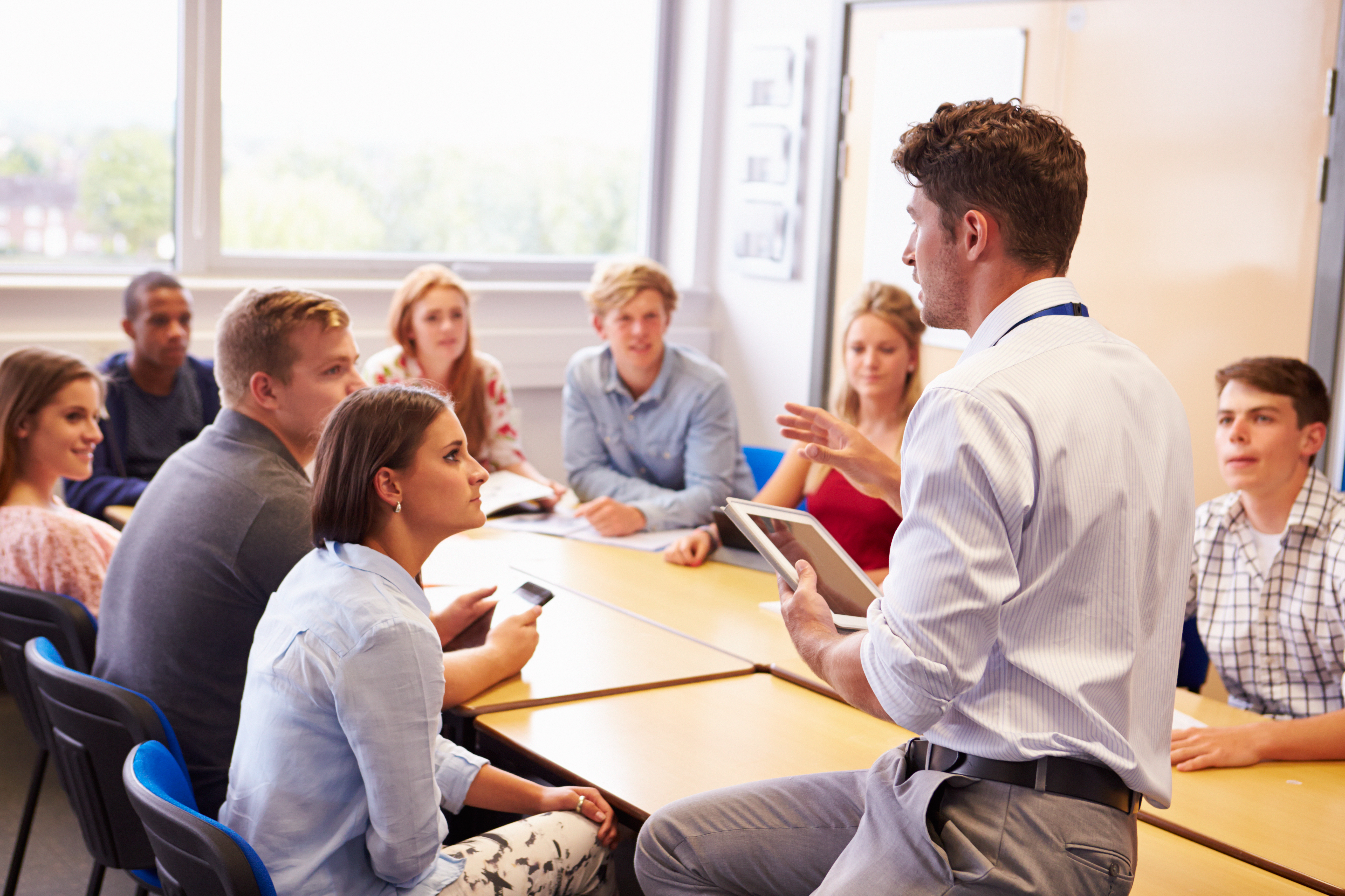 college students in a classroom with a professor providing instruction