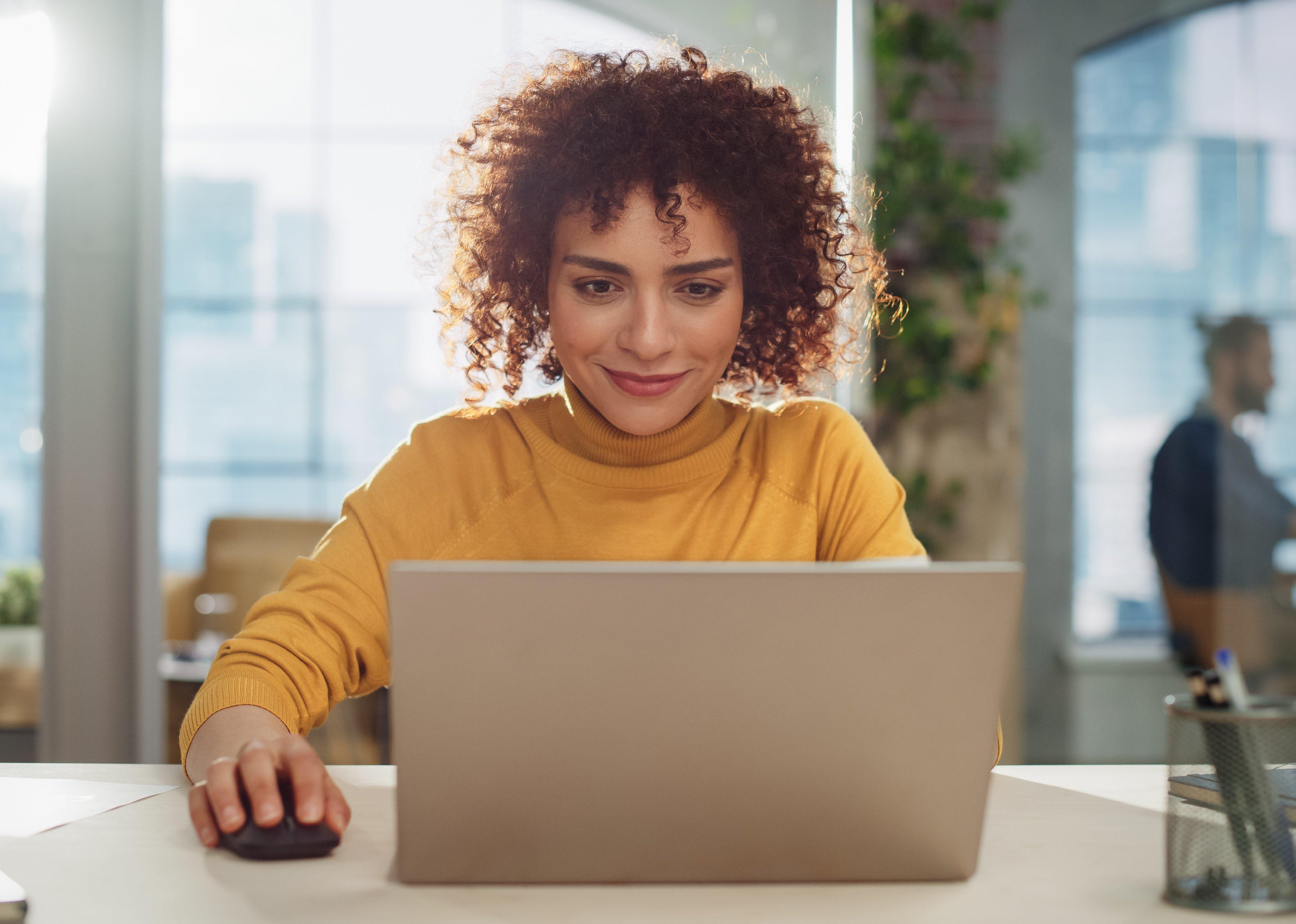 Young woman with curly hair on computer.