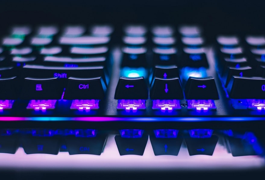 close up a computer keyboard, bathed in blue-purple light