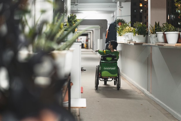 A man uses a wheelchair to navigate his way through an office