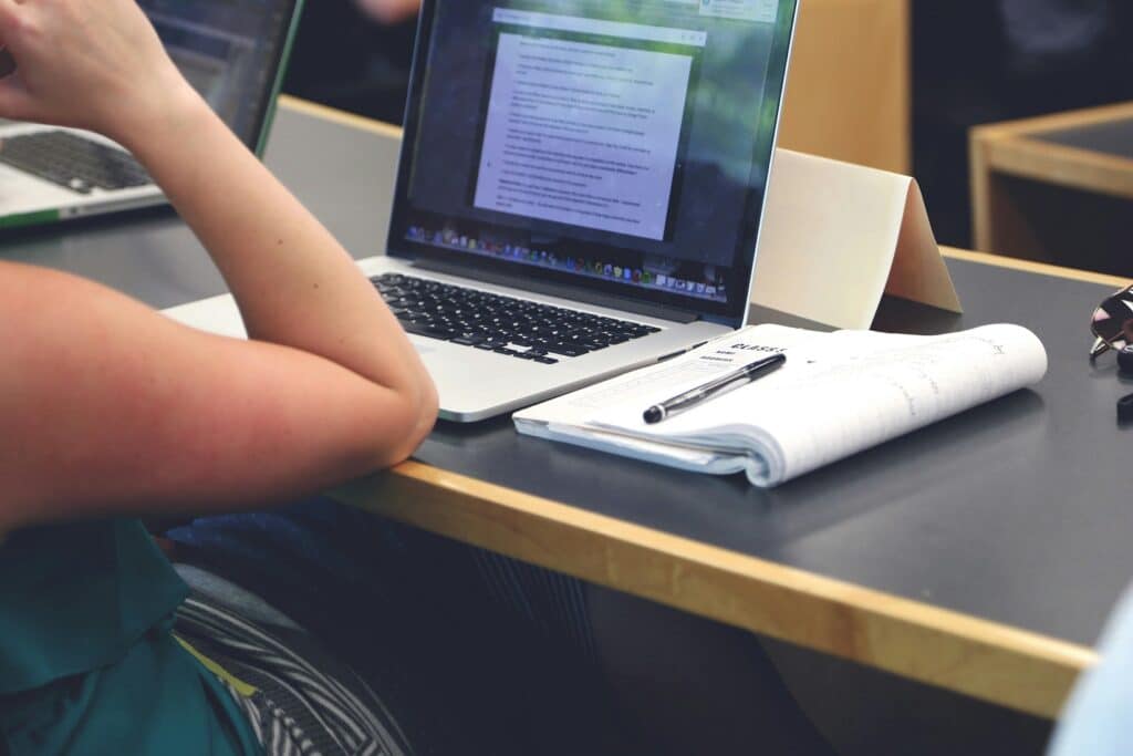 Close-up of an open laptop in a classroom.