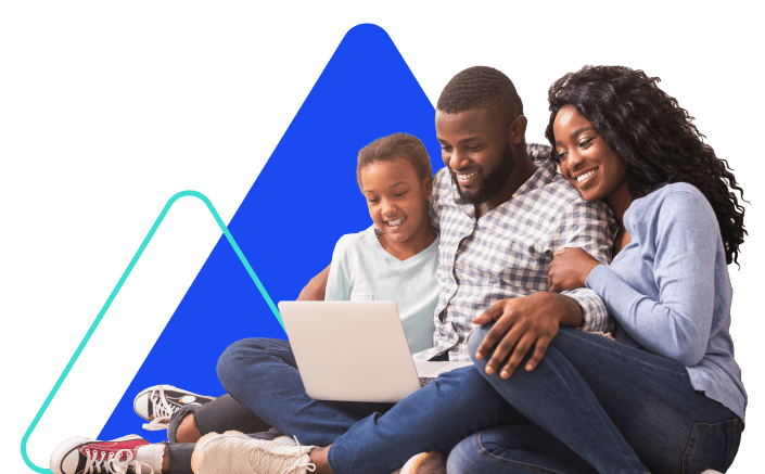 A family of three – a man, woman and young daughter – sit together and view an open laptop.