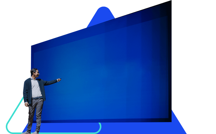 A man stands in front of and gestures towards a large blue presentation screen.