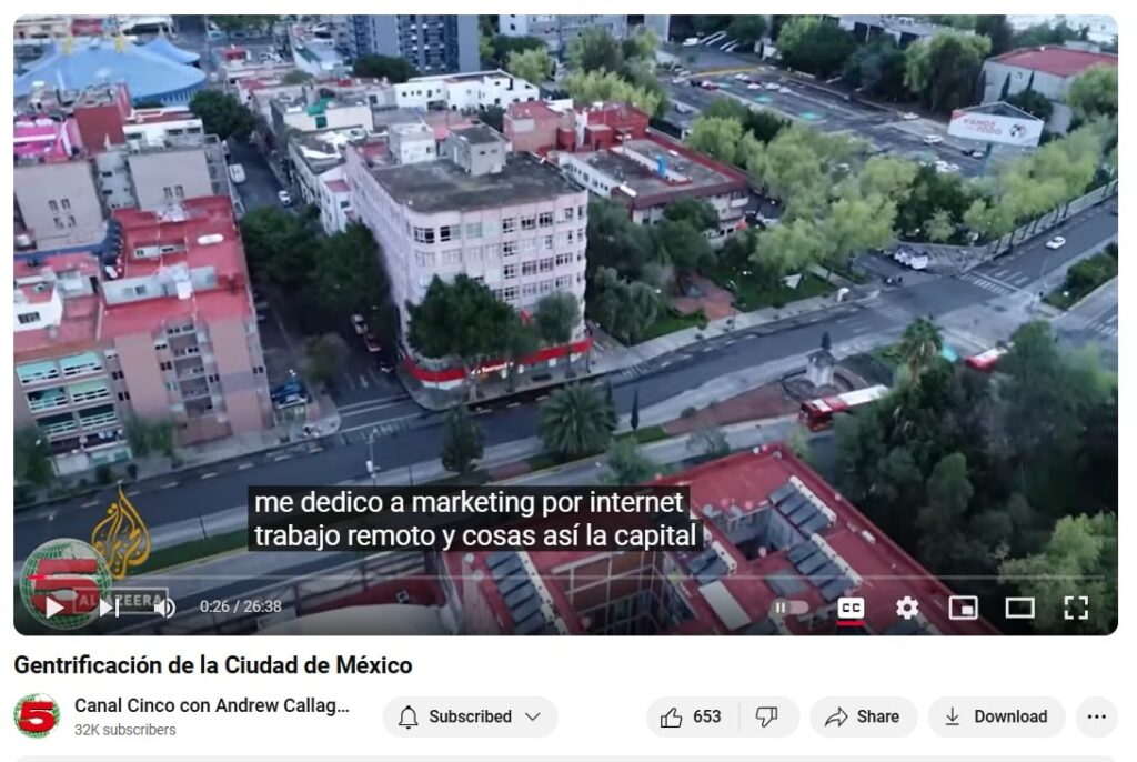 Screenshot from YouTube's Canal Cinco showing an overhead view of a town with Spanish subtitles across the screen.