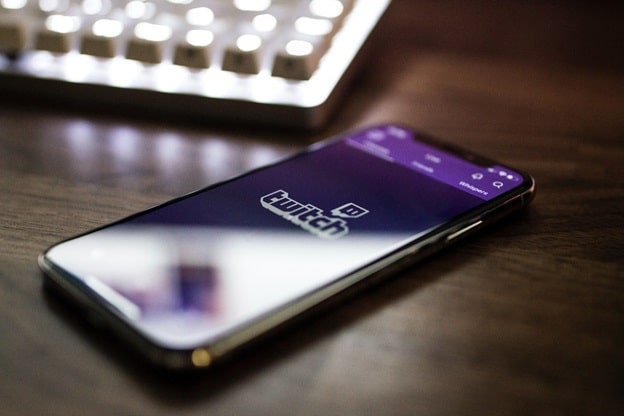 The Twitch app can be seen loading on the screen of a cell phone.