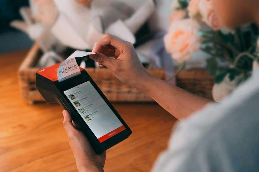 A merchant prints out a customer receipt on a handheld check-out device
