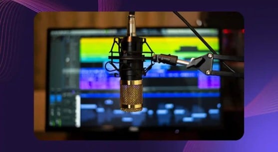 A professional microphone from a media studio is shown with sound mixers visible behind it