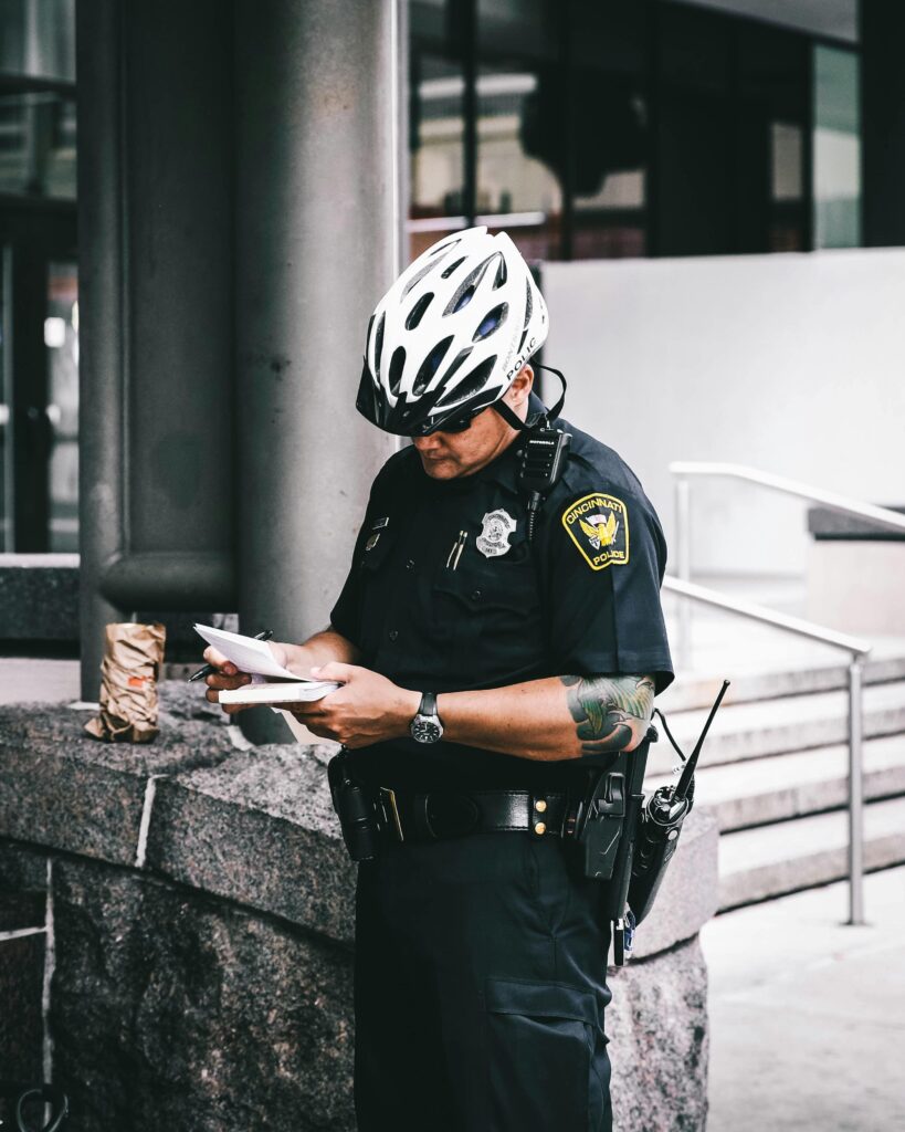 A police officer wearing a bike helmet writes a report