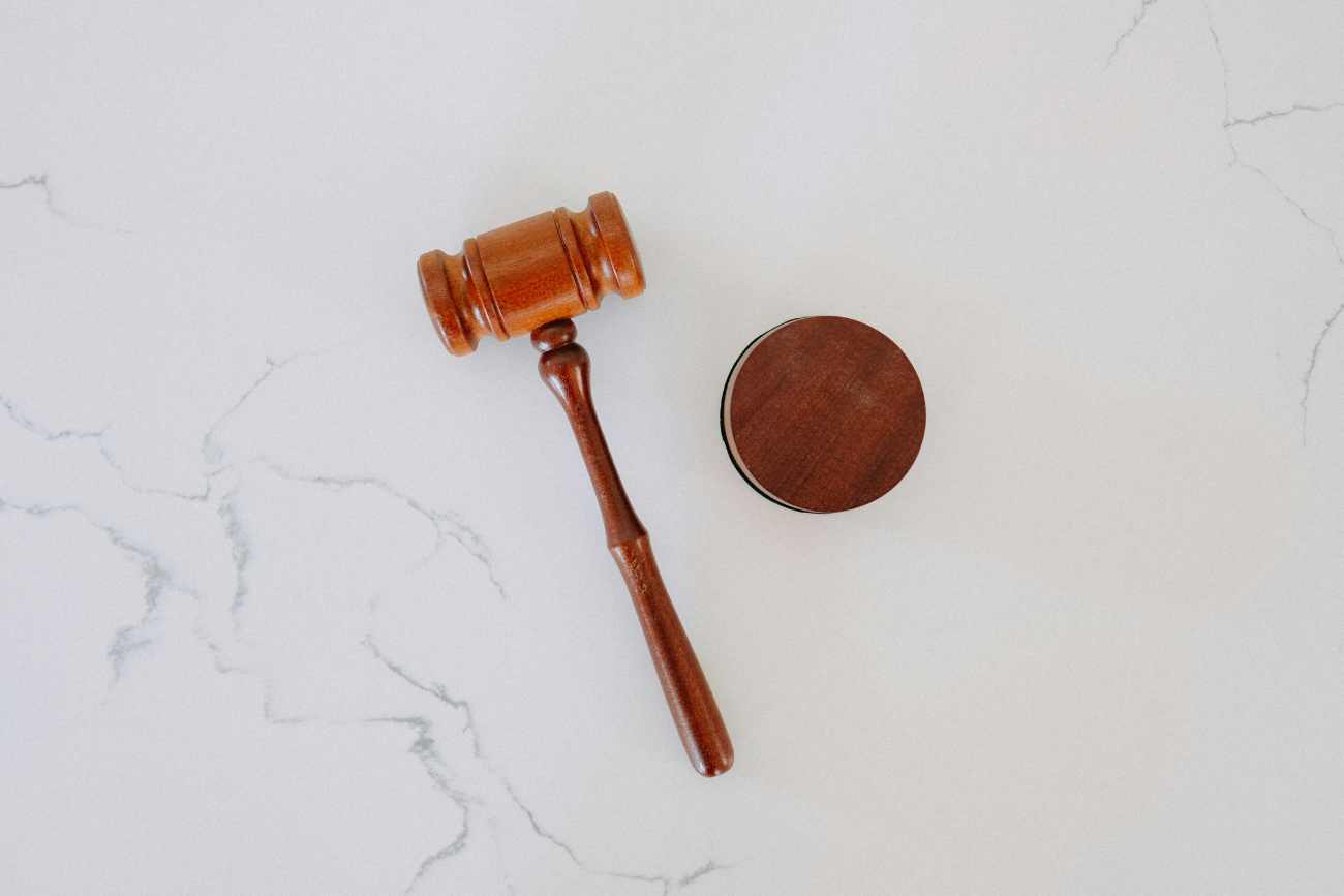Wooden gavel lays on a white marble background