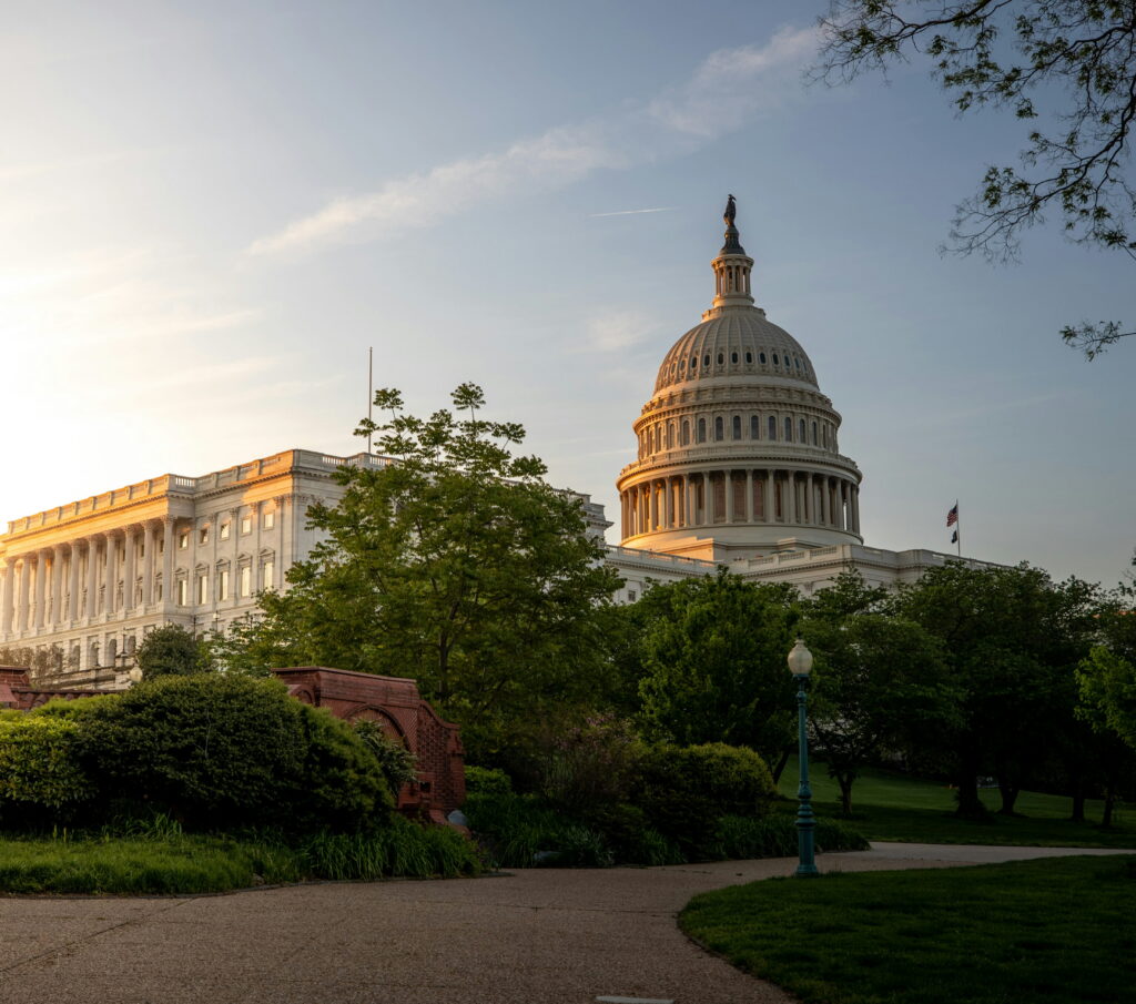 A landscape of the Capitol building in Washington DC with greenery and a path in front of it.