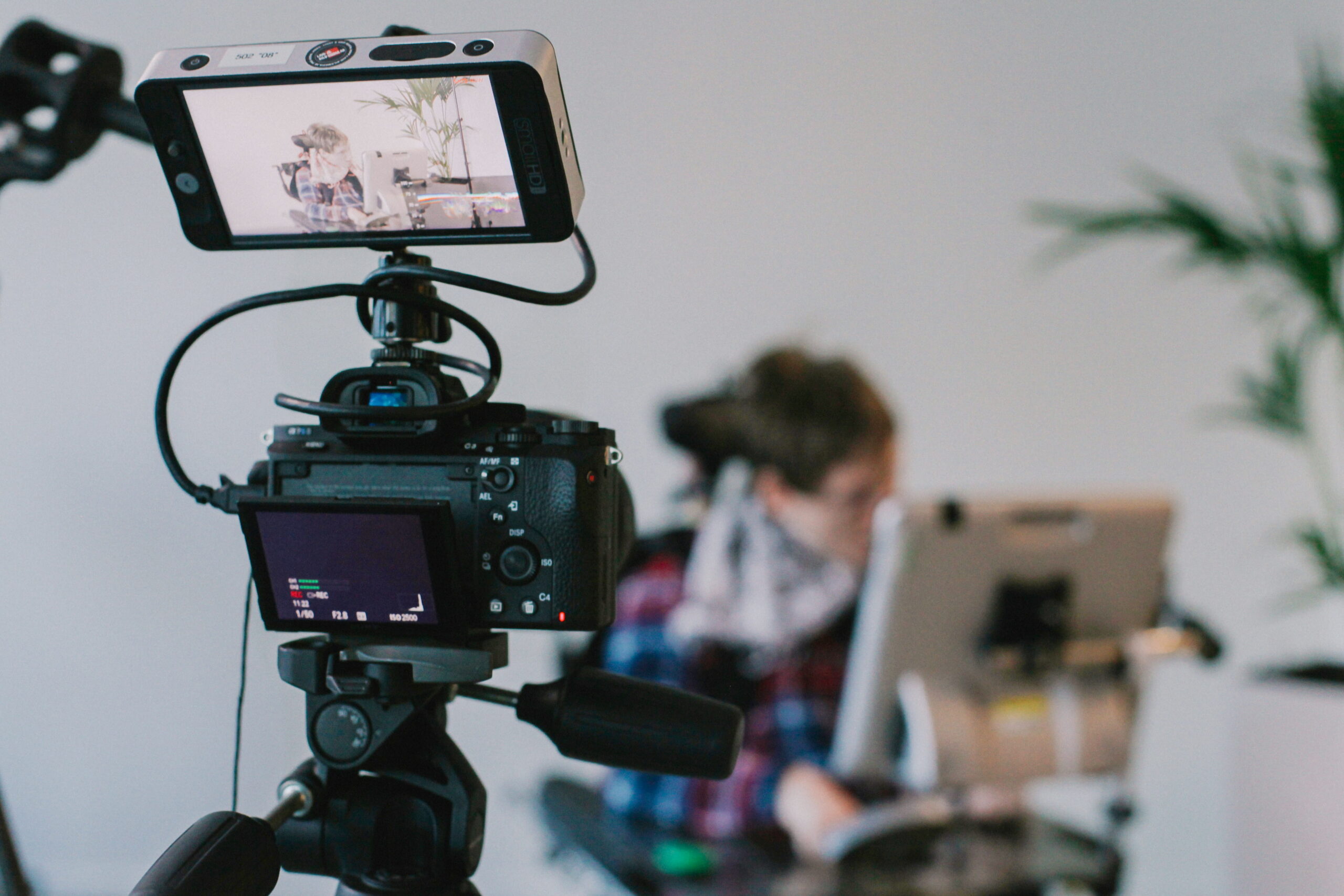 A professional camera rig equipped with an external monitor recording a subject indoors.